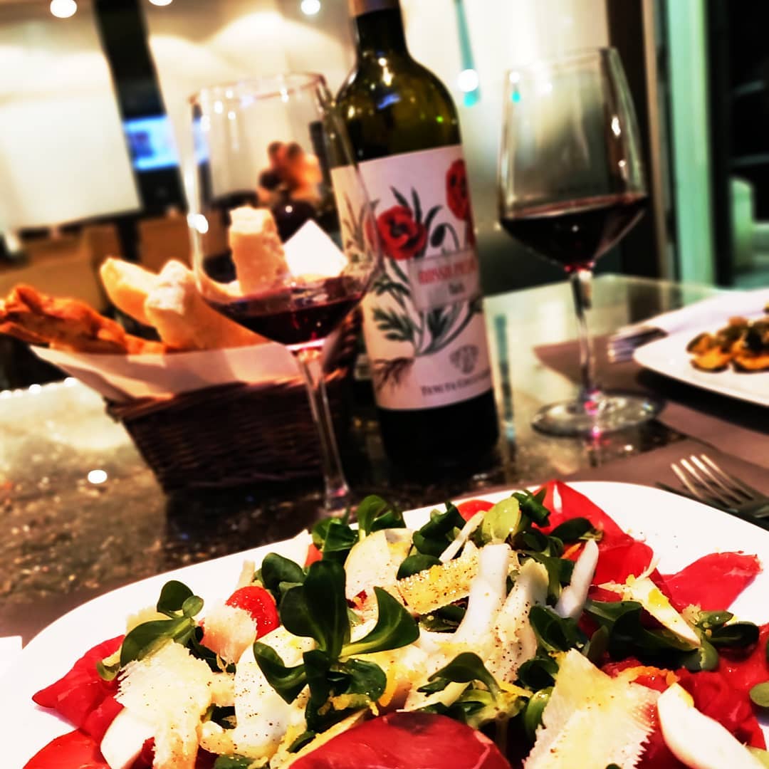 Carpaccio di bresaola con scaglie e calice di vino rosso