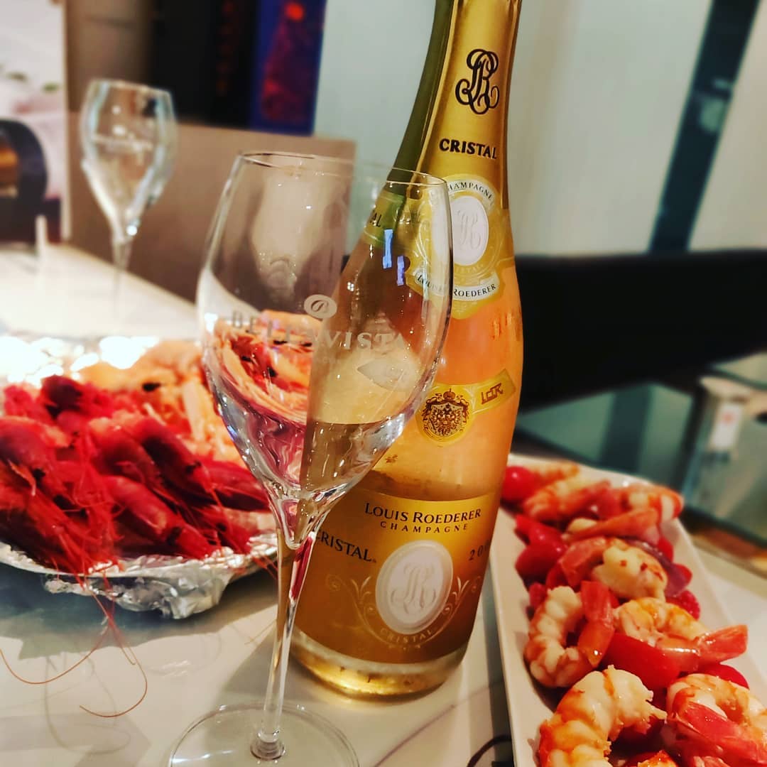 Champagne Cristal e piatti di gamberi rossi per l'aperitivo