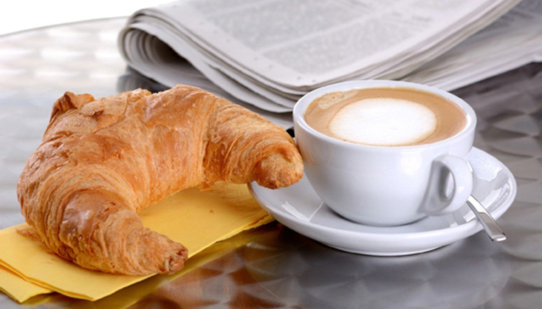 Cappuccino cremoso e cornetto appena sfornato
